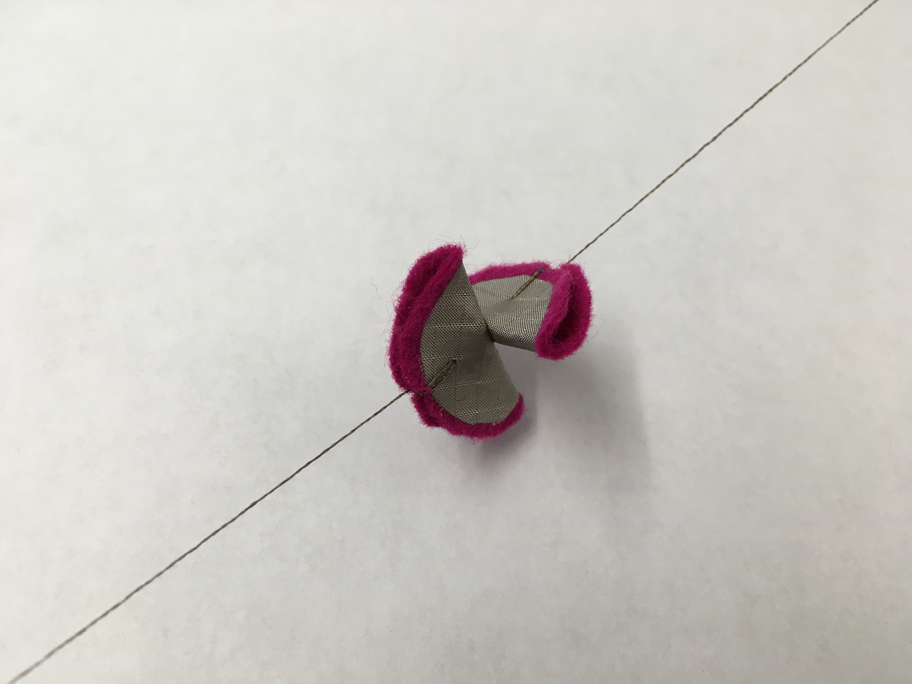 Two small pieces of felt covered in conductive fabric held in contact with tiny magnets